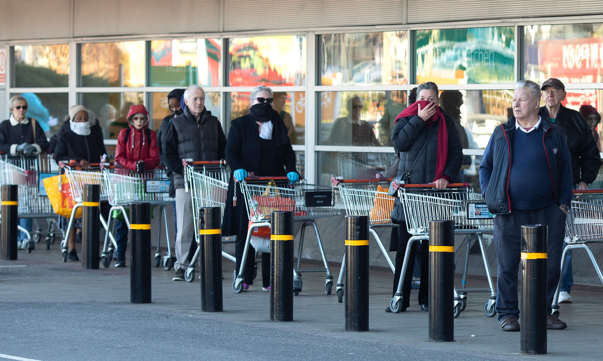 shoppers queuing with trolleys